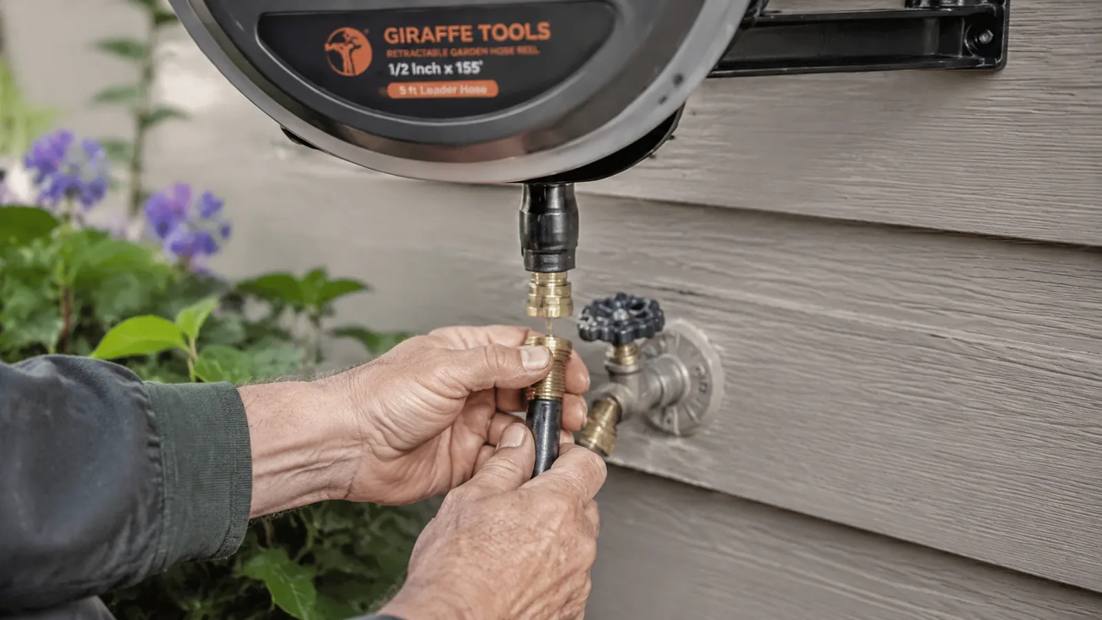 Close-up of hands connecting the short leader hose from a retractable reel to an outdoor spigot